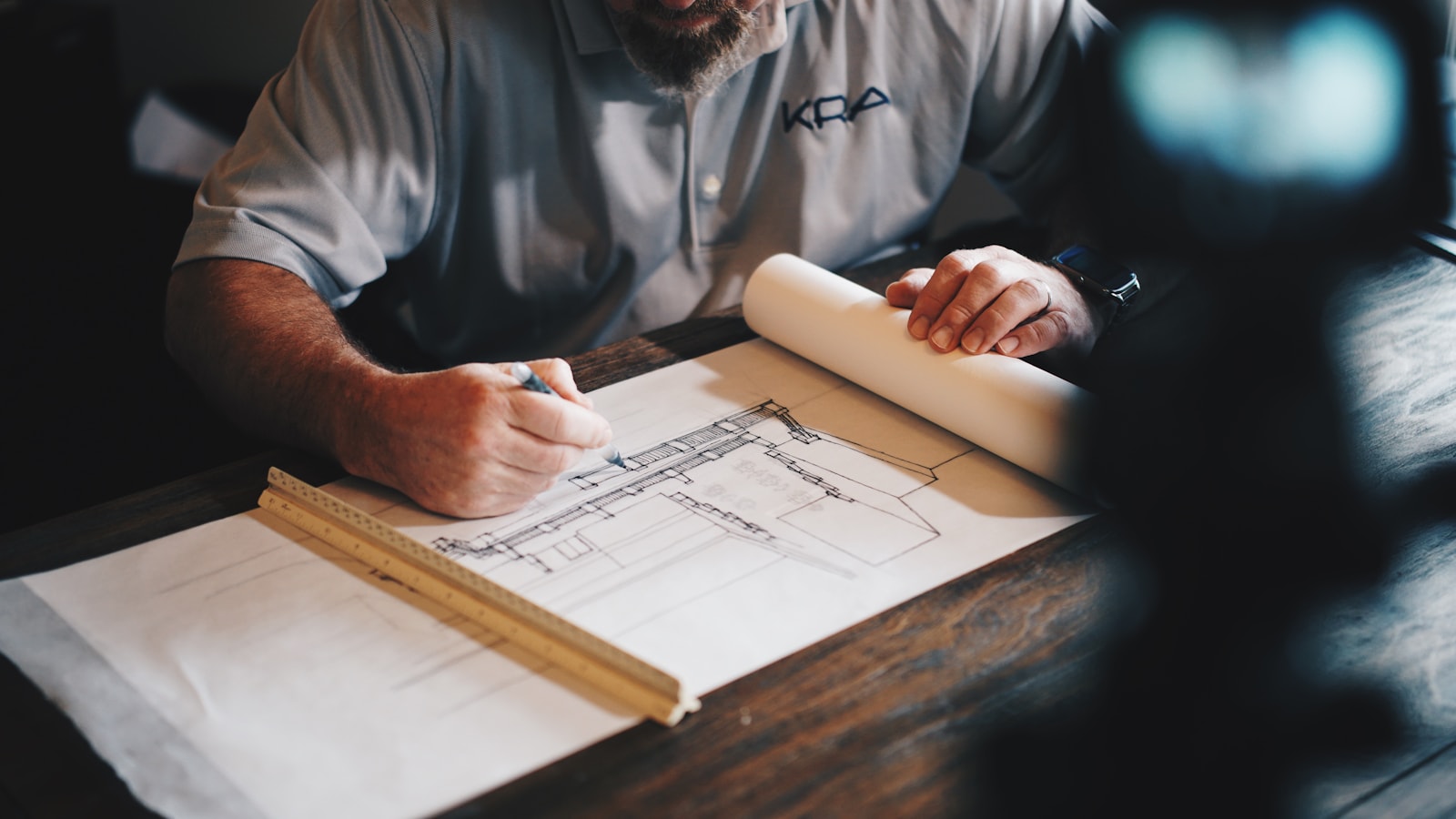 Professional reviewing architectural drawings with a scale ruler